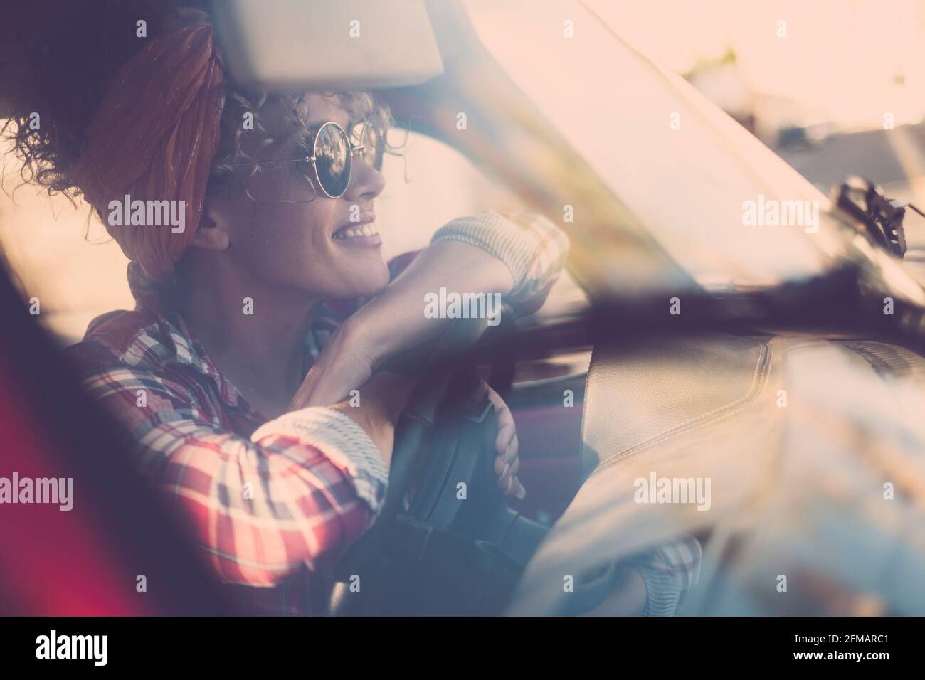 Giovane bella donna adulta sorriso e godere libertà felicità seduta all'interno dell'auto guardando fuori il vetro - donna trendy people travel - emancipazione carino donna stile di vita driver Foto Stock