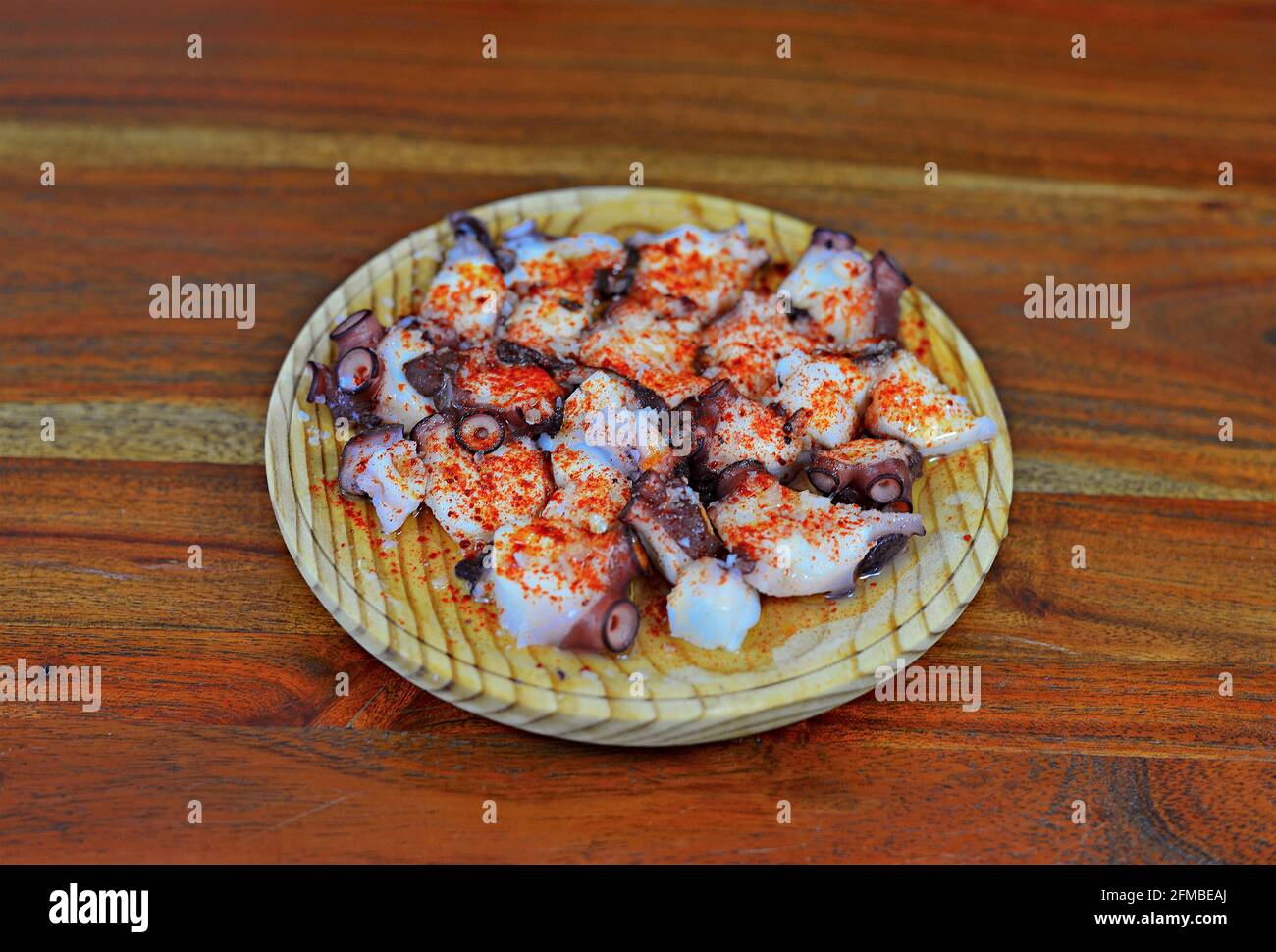 Piatto di polpo galiziano su un tavolo di legno Foto Stock
