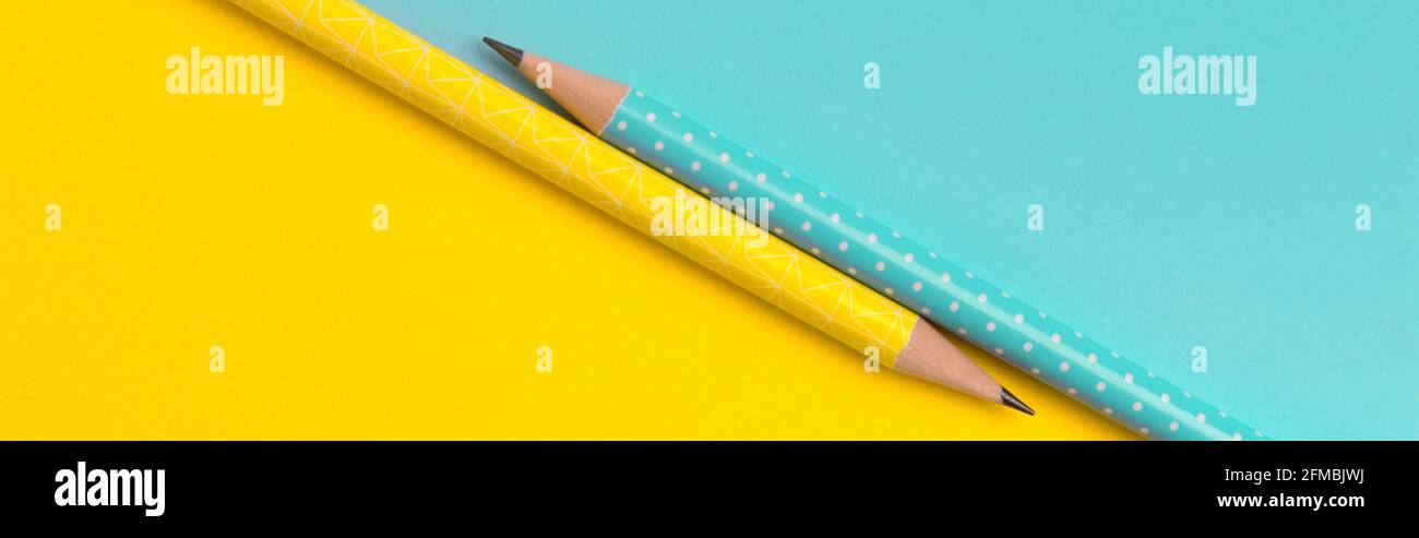 Vista superiore del turchese e giallo matite colorate su carta creative sfondo Foto Stock