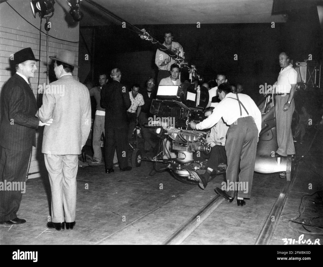 JAMES CAGNEY su set Candid con Movie Crew tra cui Cinematografo J. PEVERELL MARLEY (estrema destra) durante le riprese di KISS DOMANI ADDIO 1950 regista GORDON DOUGLAS sceneggiatura Harry Brown dal romanzo di Horace McCoy William Cagney Productions / Warner Bros. Foto Stock