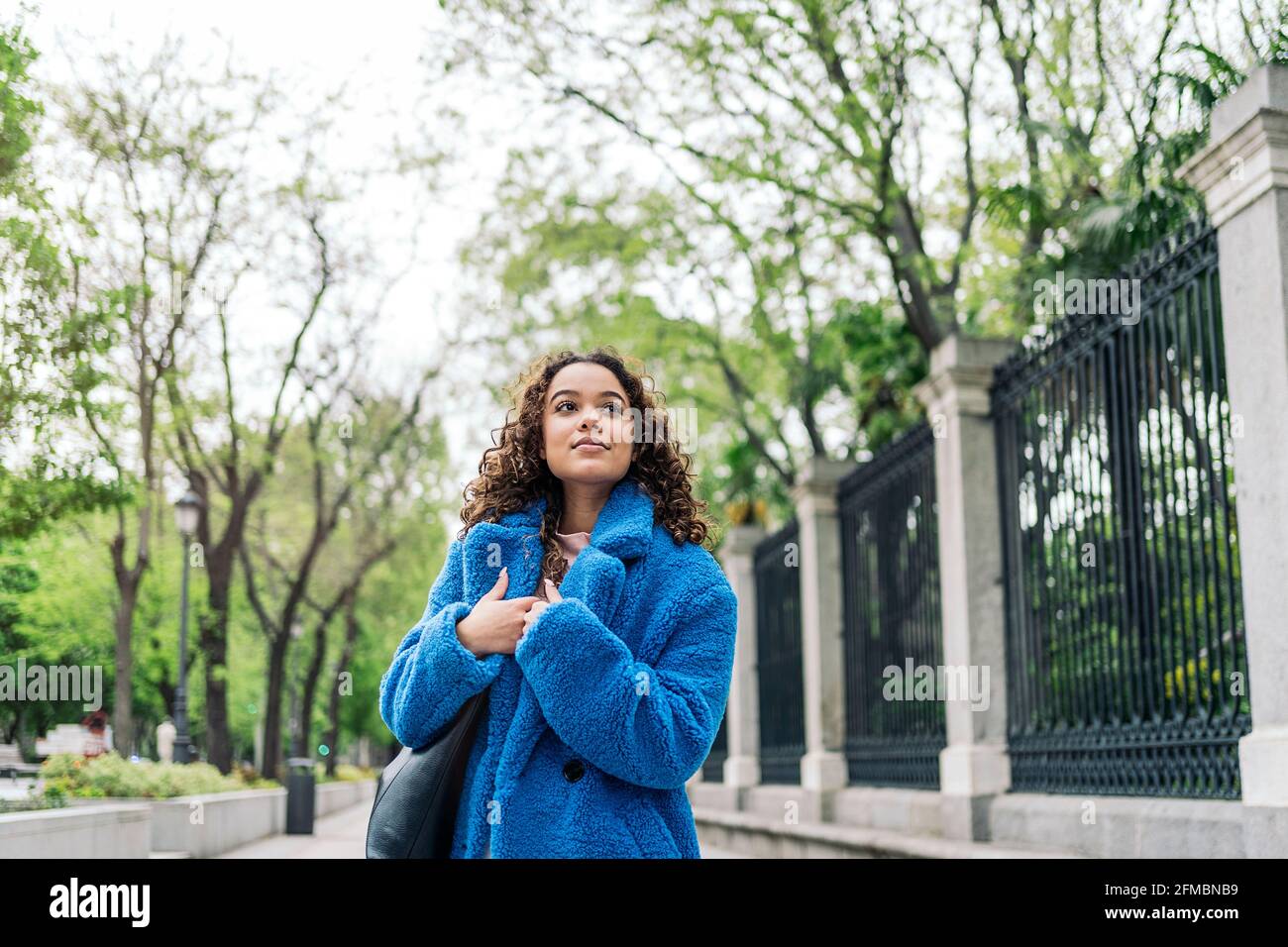 Ritratto di una donna sorridente e alla moda in strada Foto Stock