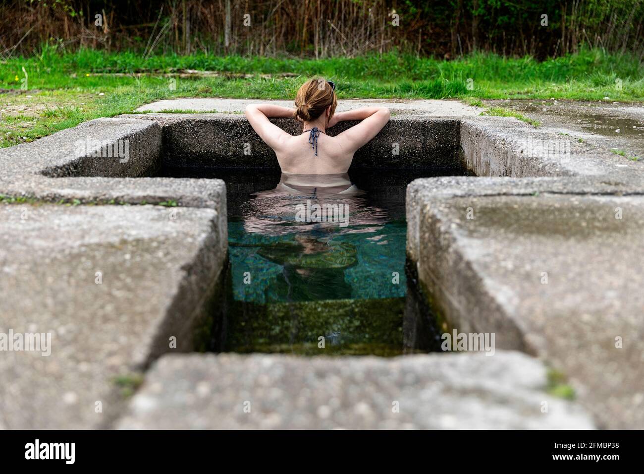 Donna che si rilassa in una sorgente termale all'aperto Foto Stock