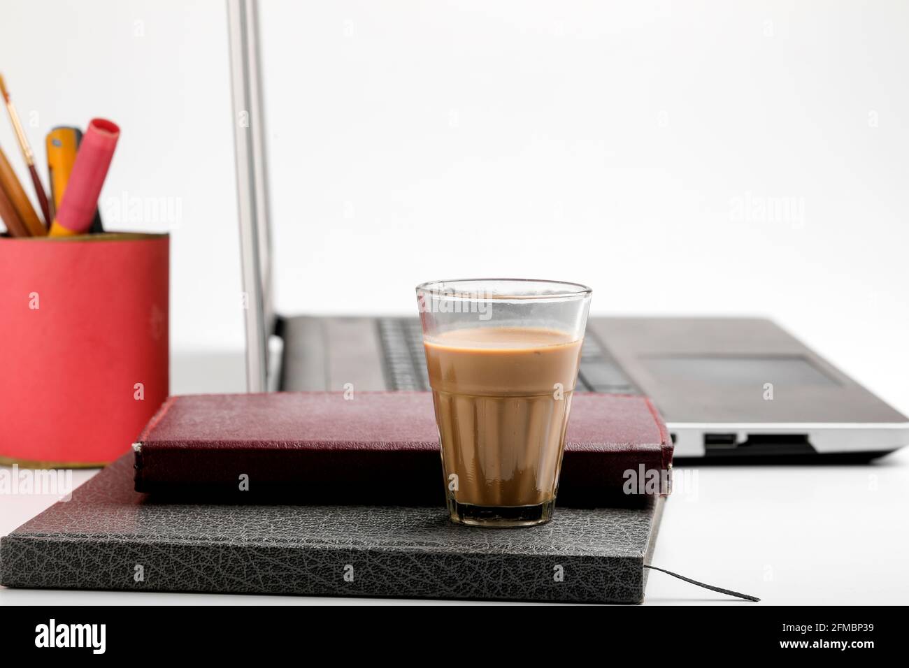 Laptop e Diario con tazza di tè. Concetto di lavoro da casa Foto Stock