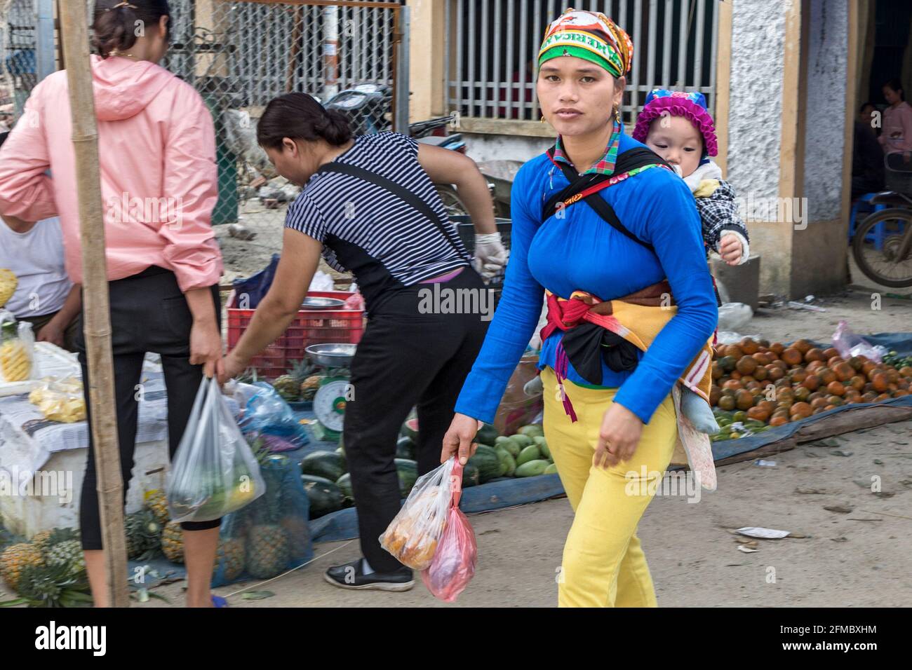 Donna con bambino, Dao (Zao) Ao dai minoranza etnica, Quyet Tien mercato di minoranza etnica, ha Giang provincia, Vietnam del Nord Foto Stock