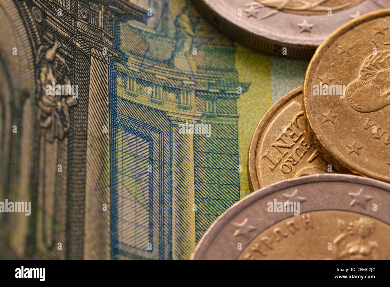 Serie di macro shot di monete in euro. Primo piano di 100 euro di bolletta con alcune monete su di esso come sfondo Foto Stock