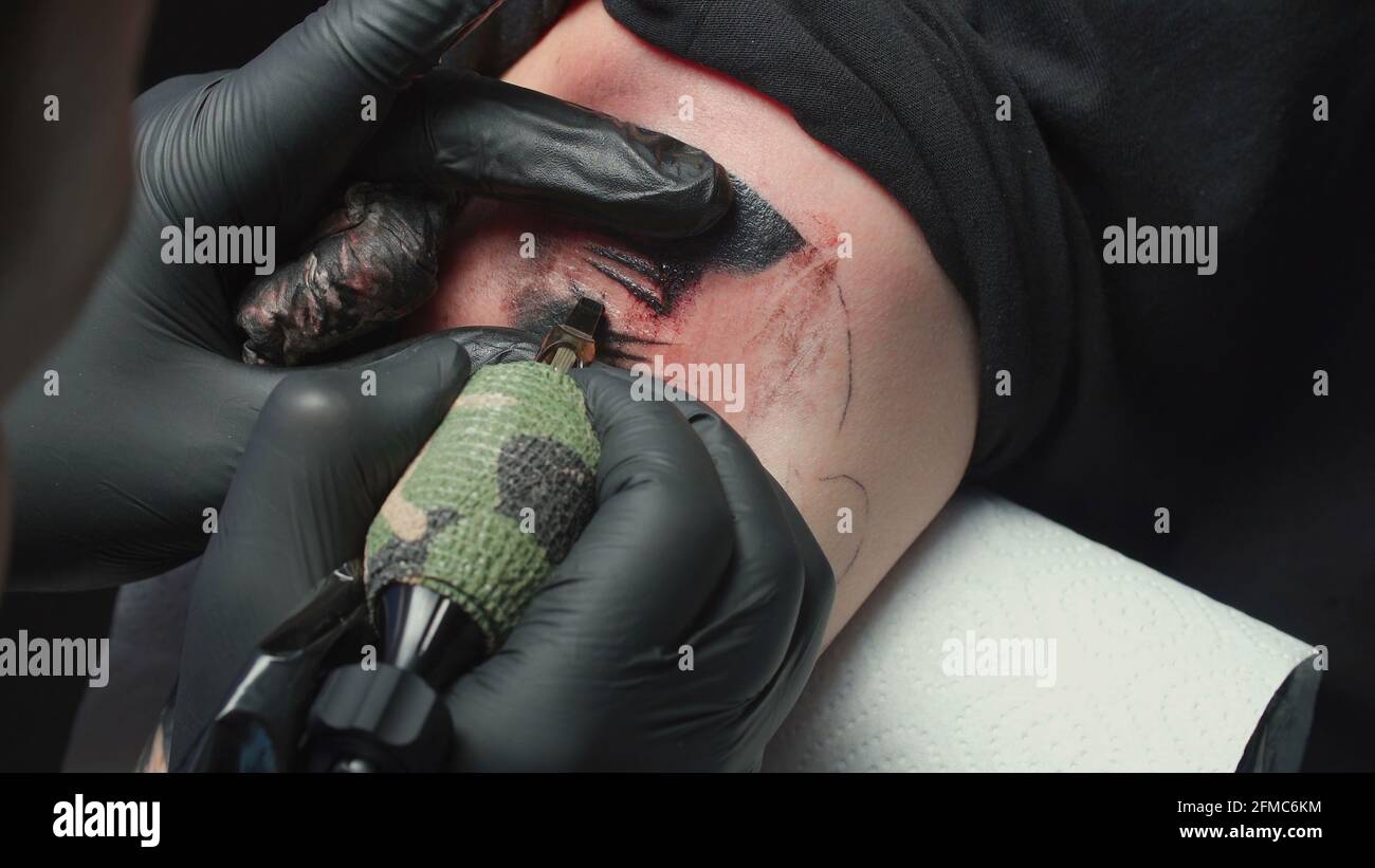 Uomo tatuista ottenere tatuaggio di serpente, closeup Foto Stock