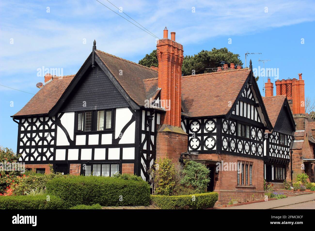 Grado II elencato Casa incorniciata in legno con tetto piastrellato da Douglas & Fordham in Thornton Hough, Wirral, Regno Unito Foto Stock