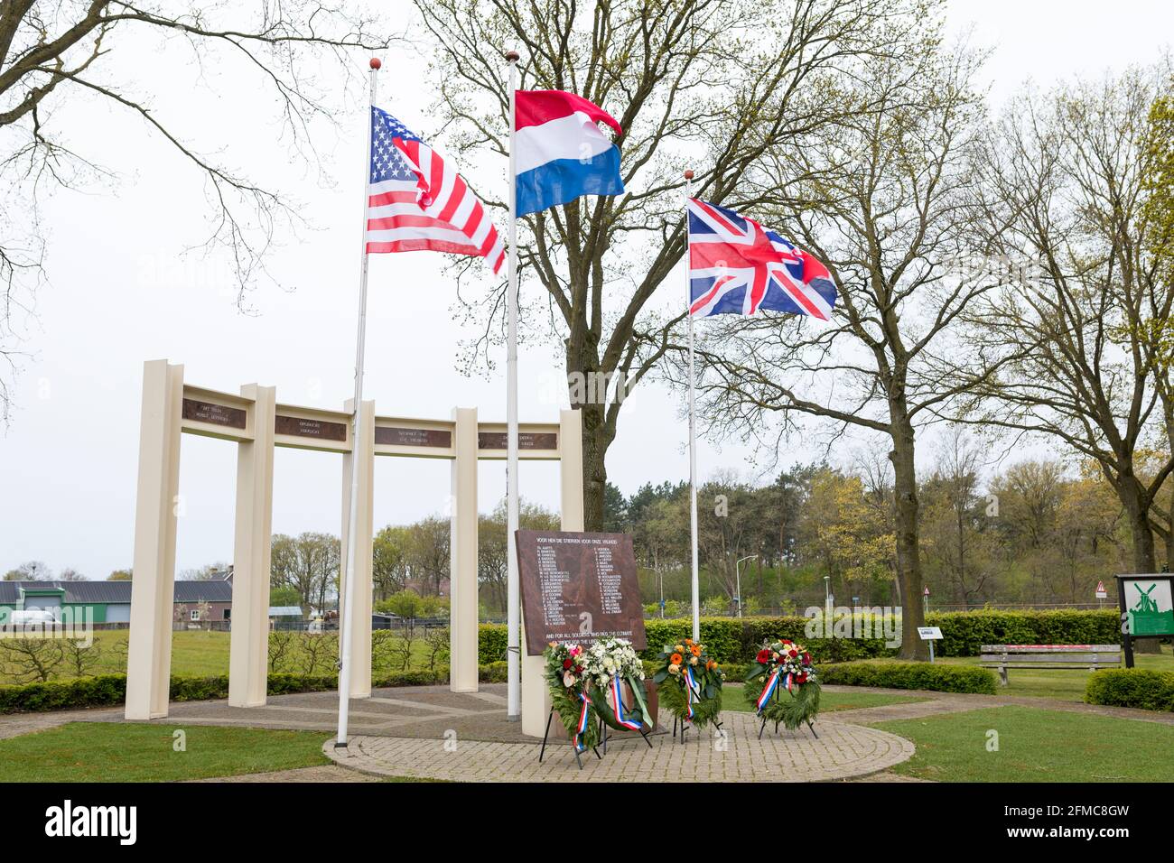 BANDIERA STATUNITENSE, britannica e olandese sventolando al monumento commemorativo per soldati caduti e civili durante la liberazione di Liessel, Paesi Bassi Foto Stock