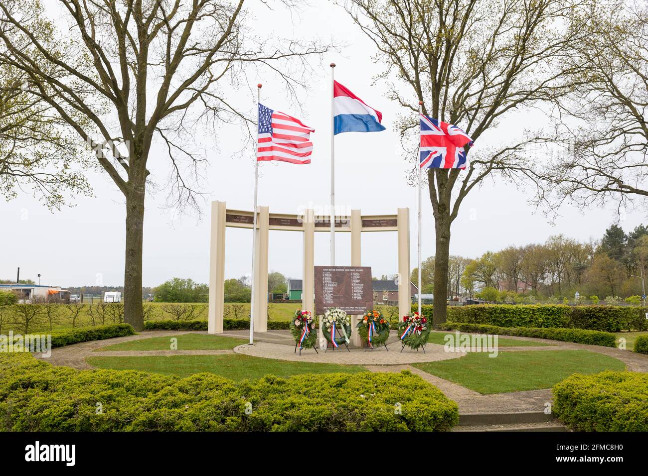 BANDIERA STATUNITENSE, britannica e olandese sventolando al monumento commemorativo per soldati caduti e civili durante la liberazione di Liessel, Paesi Bassi Foto Stock