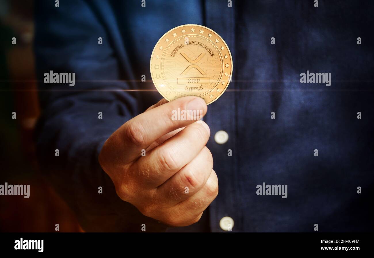 Ripple XRP simbolo di criptovaluta moneta d'oro in mano concetto astratto  Foto stock - Alamy