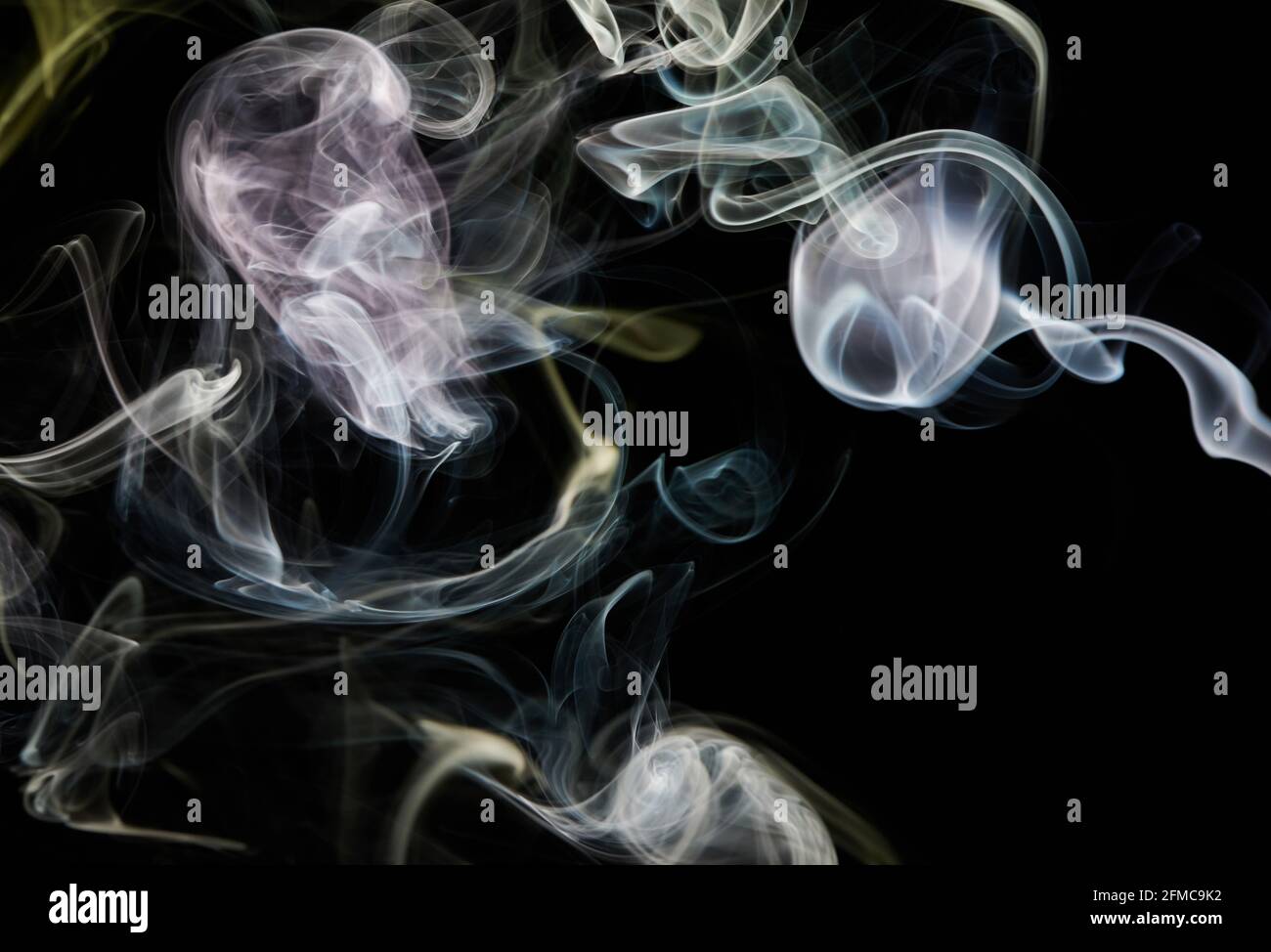 Il fumo astratto ruota e curva su sfondo nero isolato Foto Stock