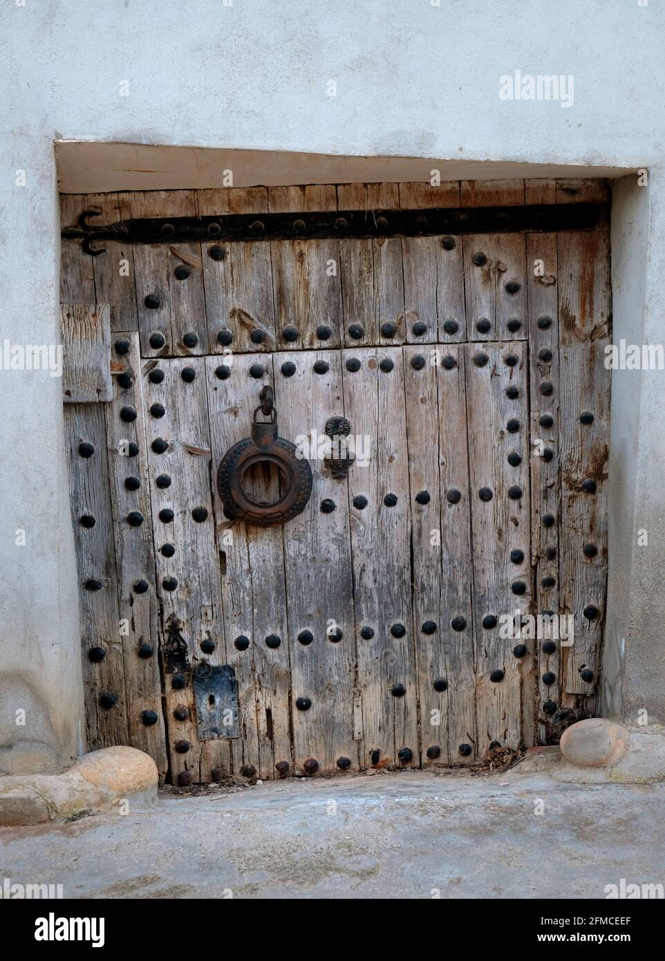 Una vecchia e delapidated chiodo-borchiata porta posteriore nel villaggio di Torrebaja in Valancia, Spagna Foto Stock