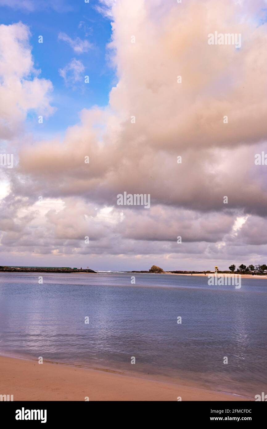 Currumbin Creek con Currumbin Rock sullo sfondo sotto il cielo nuvoloso. Foto Stock