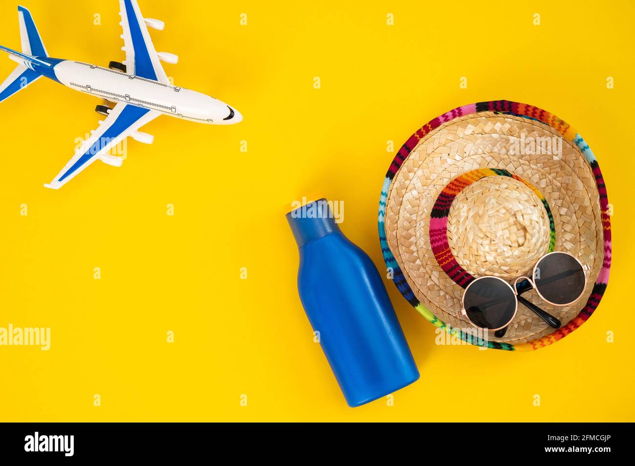 Occhiali da sole sombrero in aereo e un tubo di crema solare su sfondo  giallo. Concetto di vacanza estiva Foto stock - Alamy