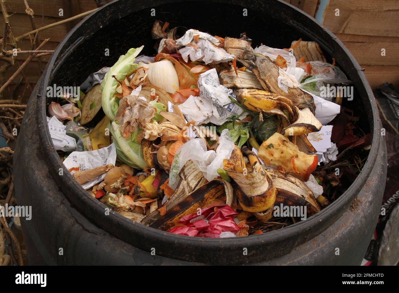 Contenuto di un bidone di compost esterno compreso spreco vegetale per produrre compost di giardino ecologico e ridurre i rifiuti. Foto Stock