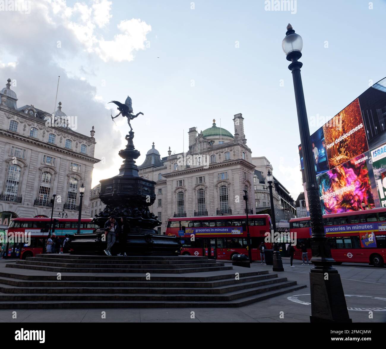 Londra, Greater London, England - Maggio 04 2021: Gli autobus di Londra nel traffico di Piccadilly Circus mentre il semaforo inizia a svanire. Foto Stock