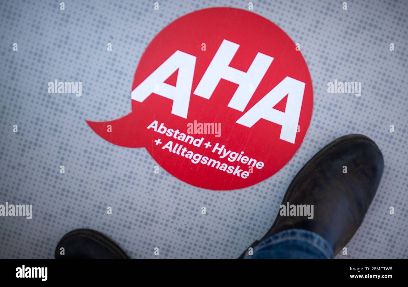 28 aprile 2021, Meclemburgo-Pomerania occidentale, Greifswald: Di fronte al locale di lavoro dei traccianti di contatto nell'ufficio distrettuale di Vorpommern-Greifswald, è appiccato sul pavimento un avviso per il rispetto delle regole di distanza. La centrale telefonica discute l'ulteriore procedura con i cittadini che devono rimanere in quarantena a causa delle misure di protezione di Corona. Foto: Jens Büttner/dpa-Zentralbild/dpa Foto Stock