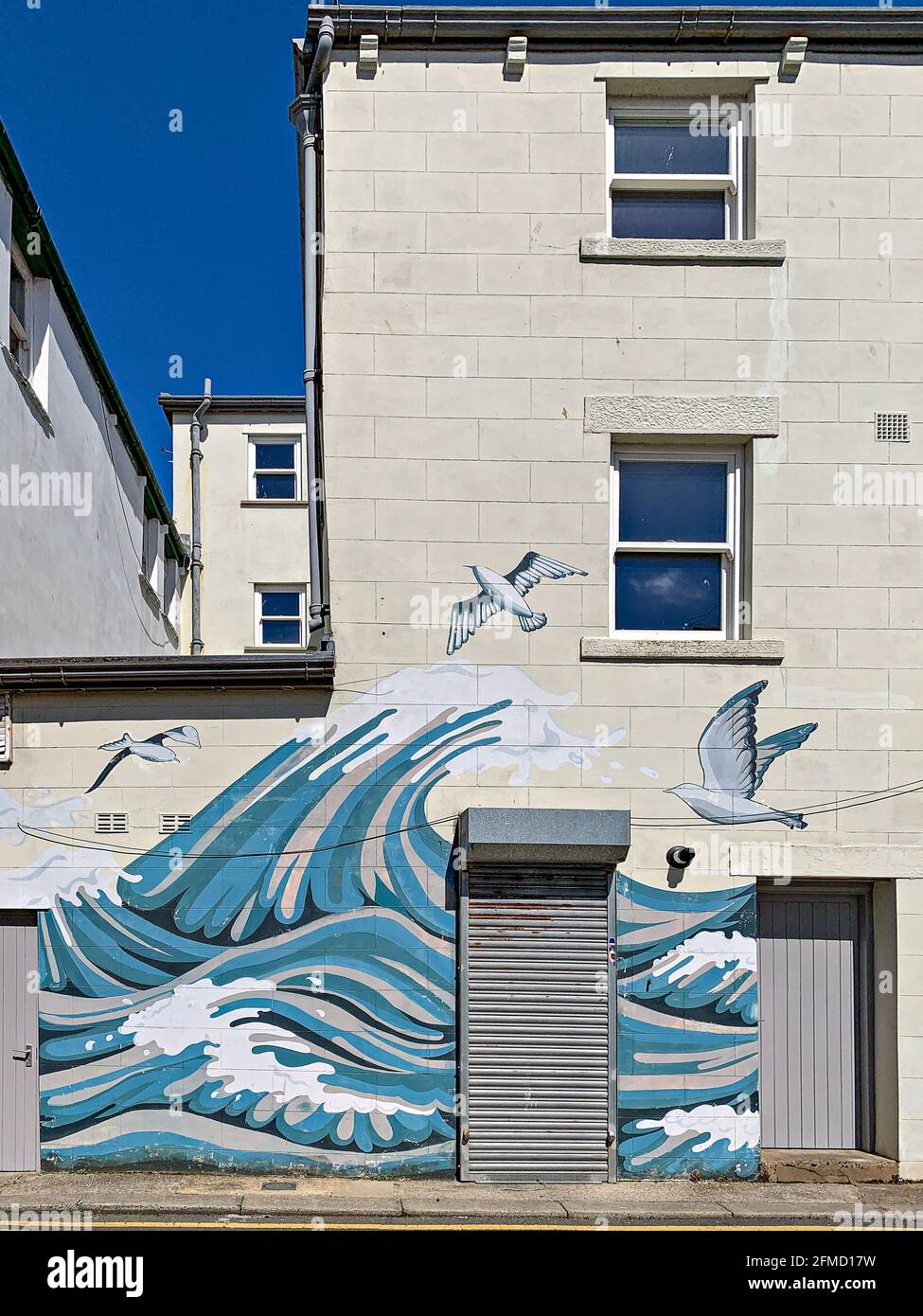 Murale sulla parete esterna di casa privata dipinta con il mare scena di  gabbiani e onde crestate Foto stock - Alamy