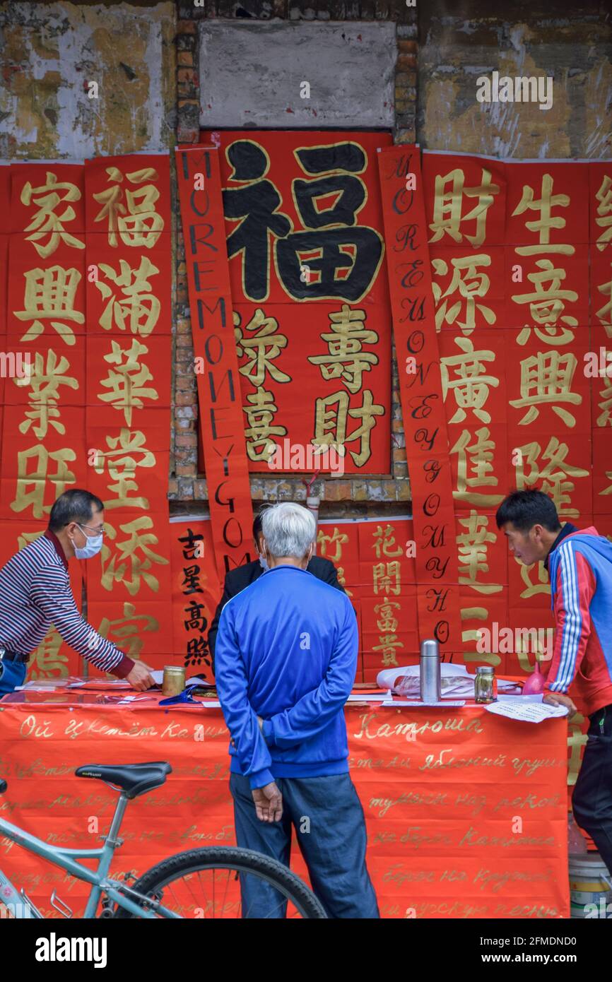 Foshan, provincia di Guangdong, Cina. 8 FEBBRAIO 2021. Un calligrafo sta scrivendo i couplets di festa della molla per la gente. È il cus più comune e importante Foto Stock