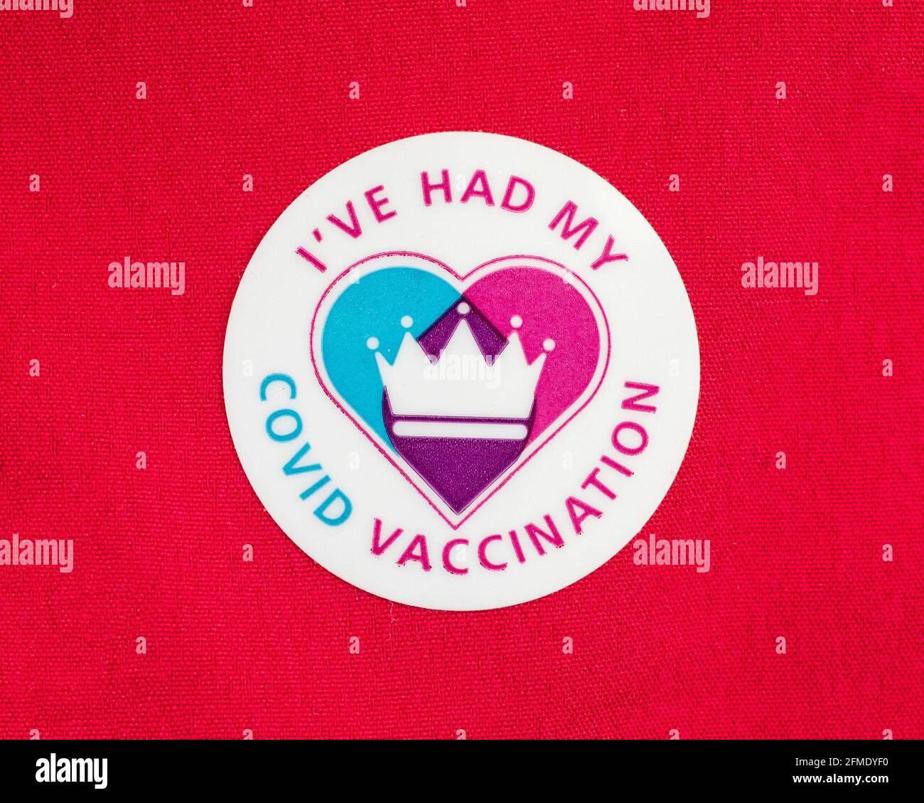 Londra, UK - 25 aprile 2021: Primo piano di un adesivo di vaccinazione di Ive Had My Covid attaccato su un materiale rosso. Foto Stock