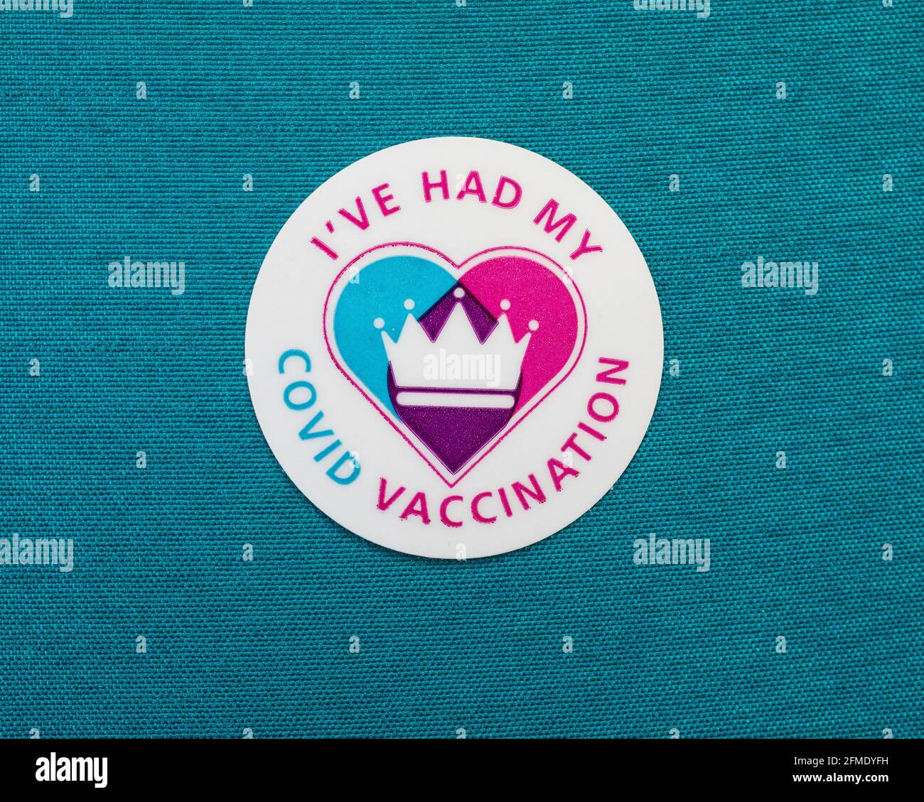 Londra, UK - 25 Aprile 2021: Primo piano di un adesivo di vaccinazione di Ive Had My Covid attaccato su un materiale colorato di teal. Foto Stock