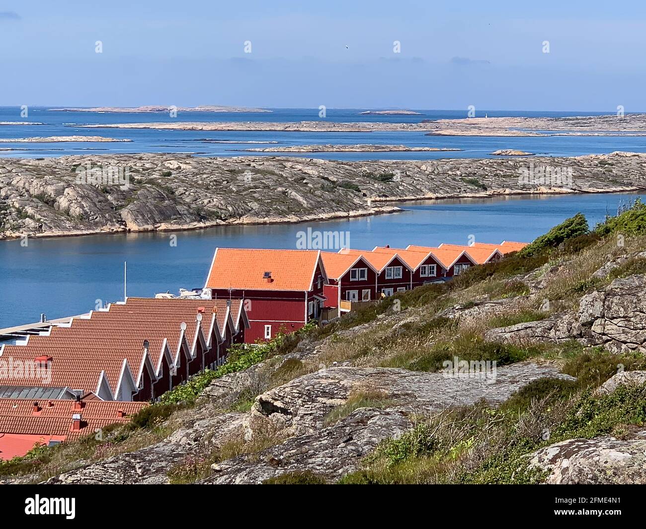 Smogen, Svezia - 1 giugno 2017: Un gruppo di tipiche case rosse svedesi sulla spiaggia di un fiordo di Smogen Foto Stock