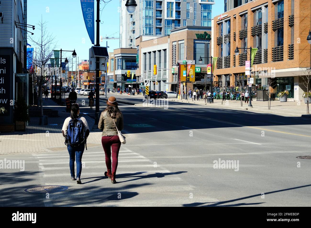 Due persone che attraversano la strada a Bank e Wilton nel Glebe. Guardando a nord. Ottawa, Ontario, Canada. Foto Stock