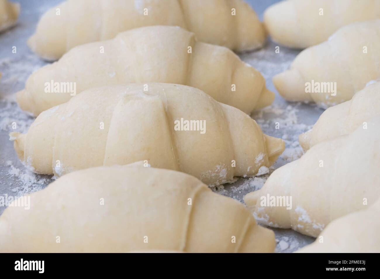 croissant preparati per essere cotti sulla teglia da forno Foto Stock