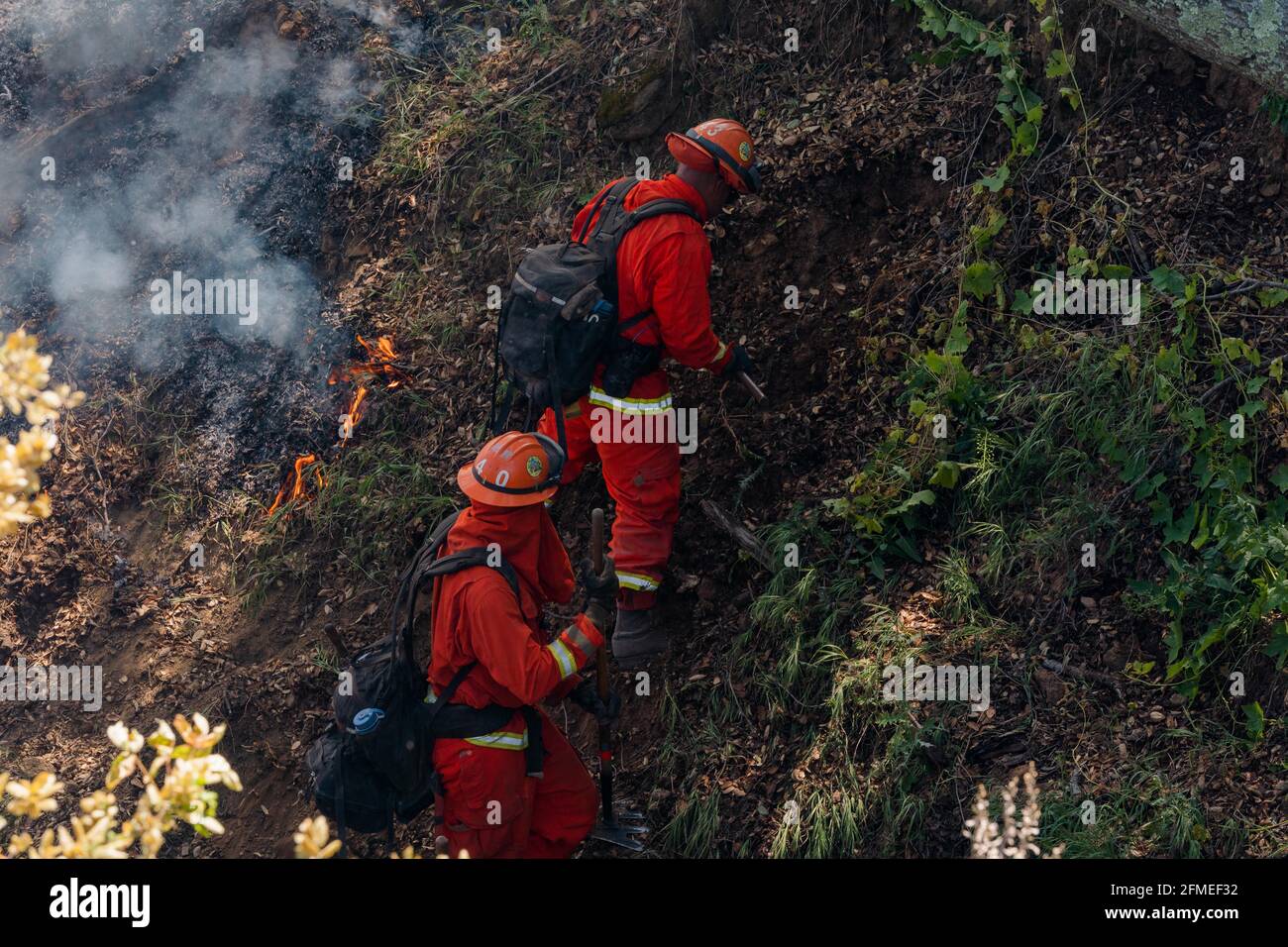 Benicia, California, Stati Uniti. 8 maggio 2021. I membri di un equipaggio a mano del Dipartimento di correzioni e riabilitazione della California Delta Camp lavorano un argine ripido all'interno di un'area di drenaggio presso il Lopes Fire. Credit: Jungho Kim/ZUMA Wire/Alamy Live News Foto Stock