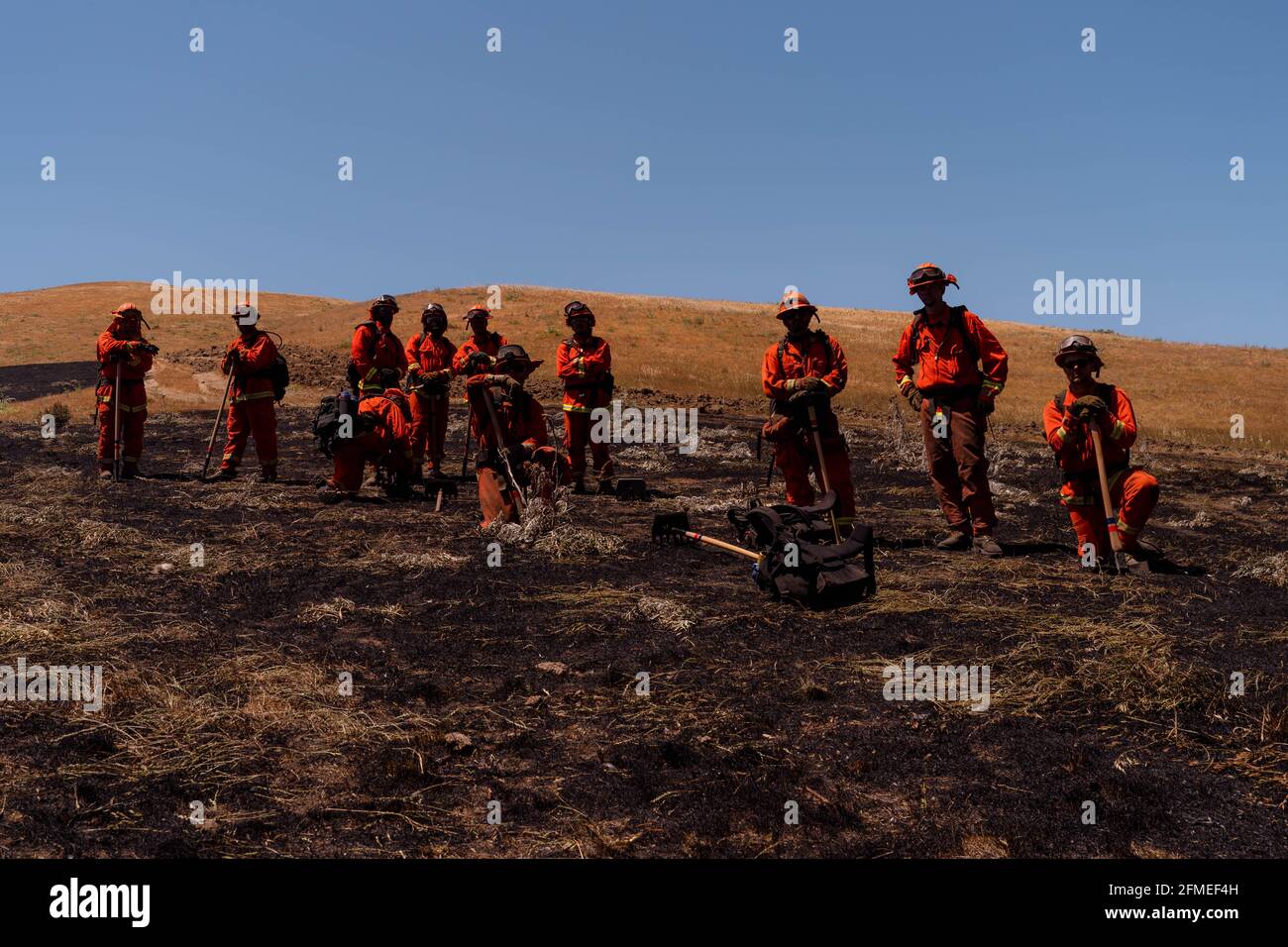 Benicia, California, Stati Uniti. 8 maggio 2021. Il Delta 2 Crew del Dipartimento di correzioni e riabilitazione della California Delta Camp fare una pausa in un campo di erba bruciata mentre si lavora sul fuoco Lopes. Credit: Jungho Kim/ZUMA Wire/Alamy Live News Foto Stock