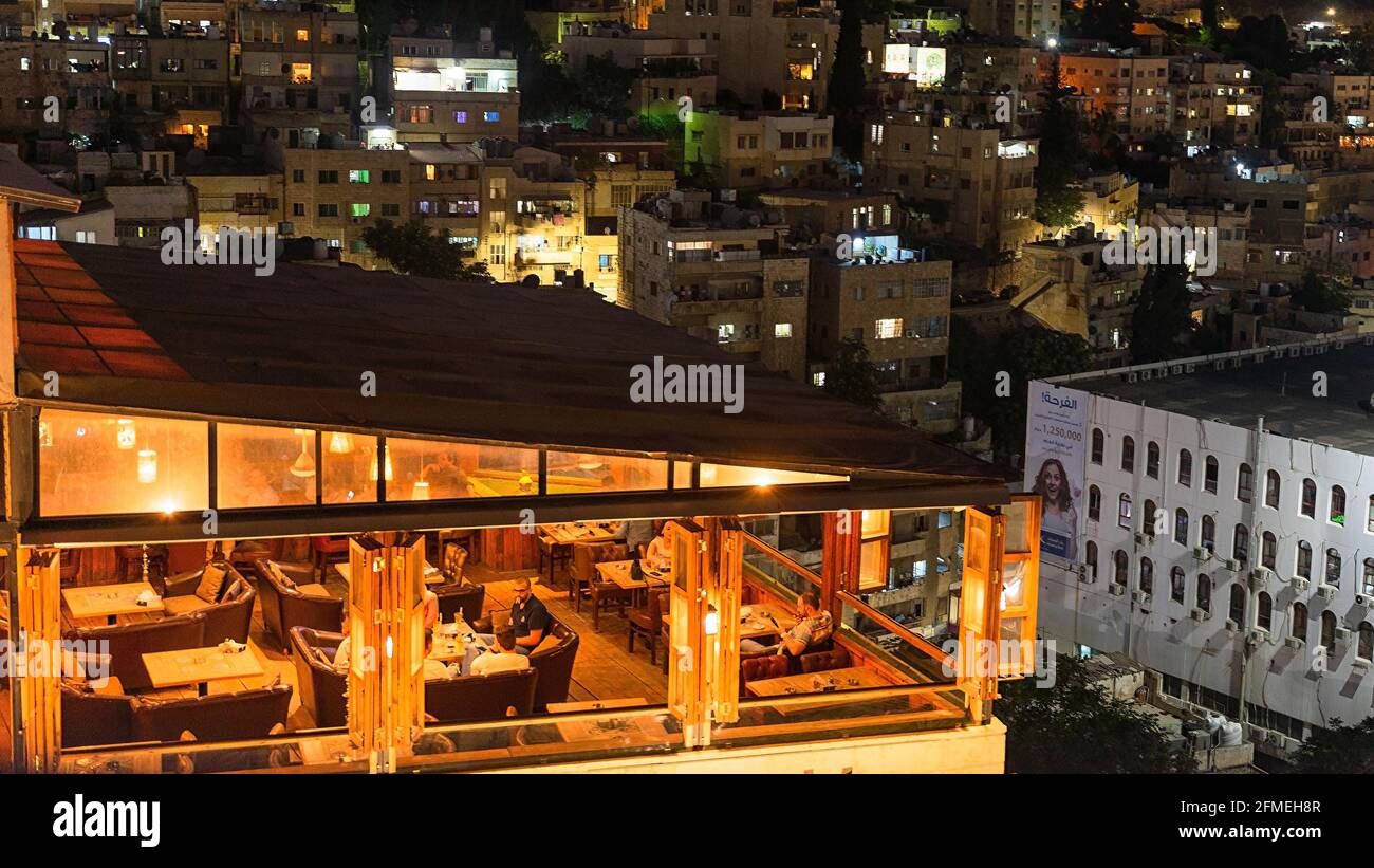 Top shot del ristorante sul tetto illuminato Talet al Jabal aperto di notte nel quartiere centrale di Amman, Giordania Foto Stock