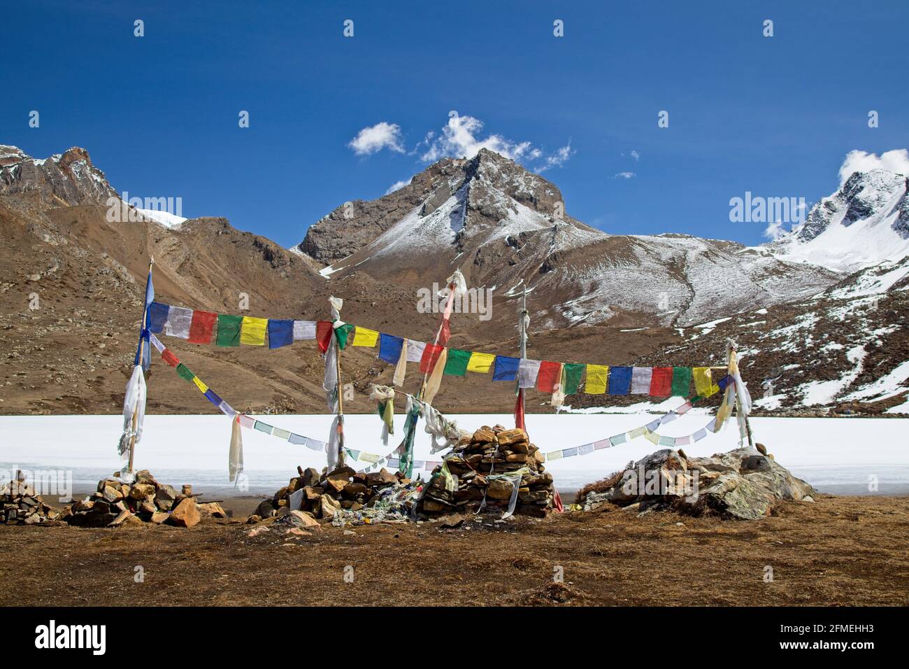 Bandiere di preghiera sul lago glaciale nelle montagne dell'Himalaya, circuito di Annapurna, Nepal. Foto Stock