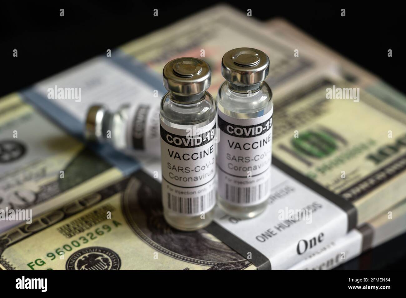 Fiale per vaccino COVID-19 e pile di dollari, bottiglie con farmaco di coronavirus su pile di denaro statunitensi. Concetto di prezzo del vaccino, costo costoso, frode, b Foto Stock