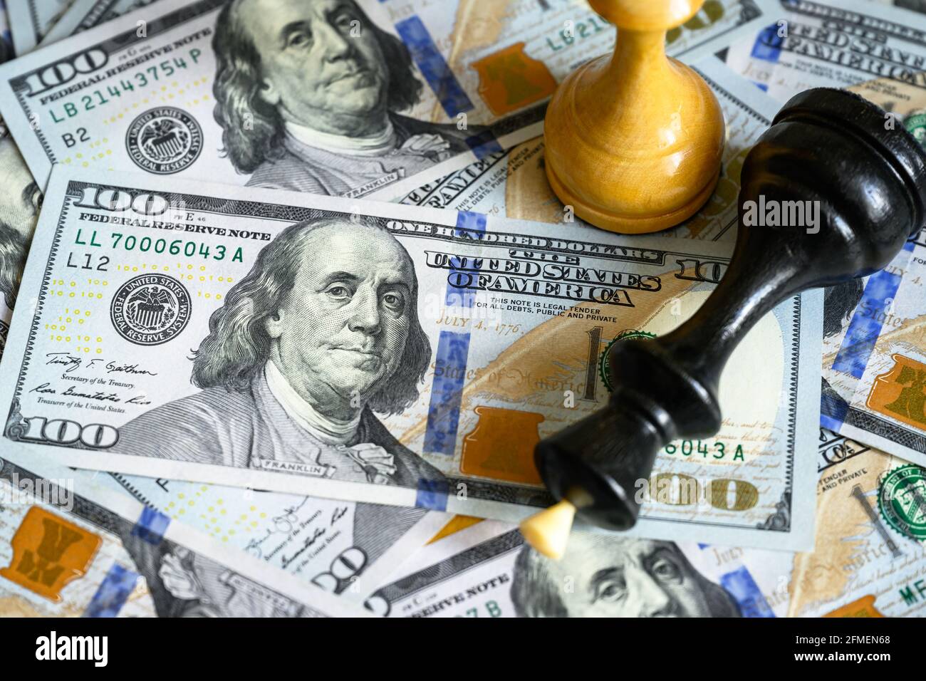 Le figure di scacchi sul mucchio delle fatture del dollaro degli Stati Uniti, il re giace sui contanti. Banconote e giochi americani. Concetto di guerra commerciale, strategia aziendale, leadership in dollari, Los Foto Stock