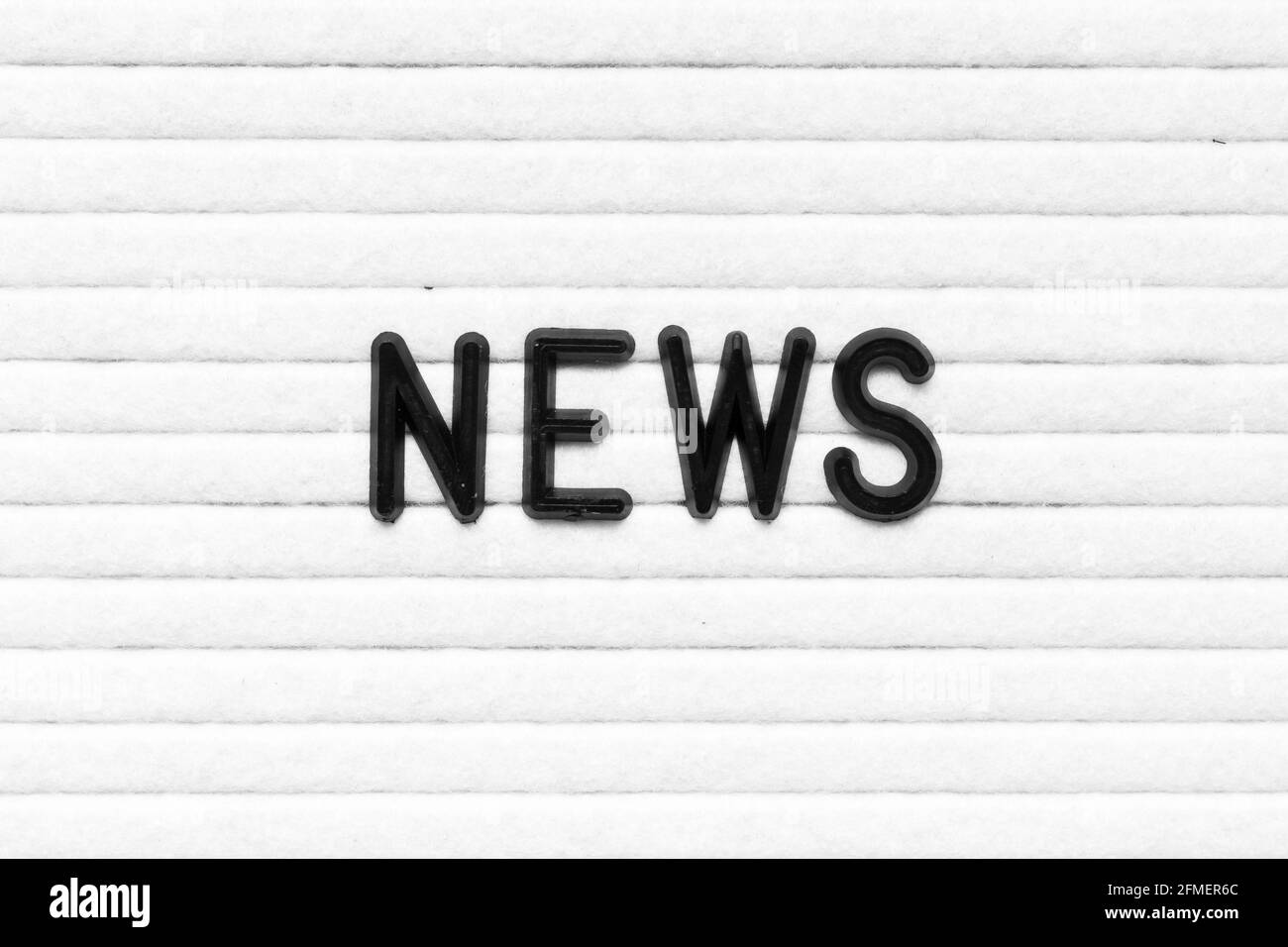 Lettera alfabetica nera nelle notizie di parola sulla lavagna bianca del feltro sfondo Foto Stock