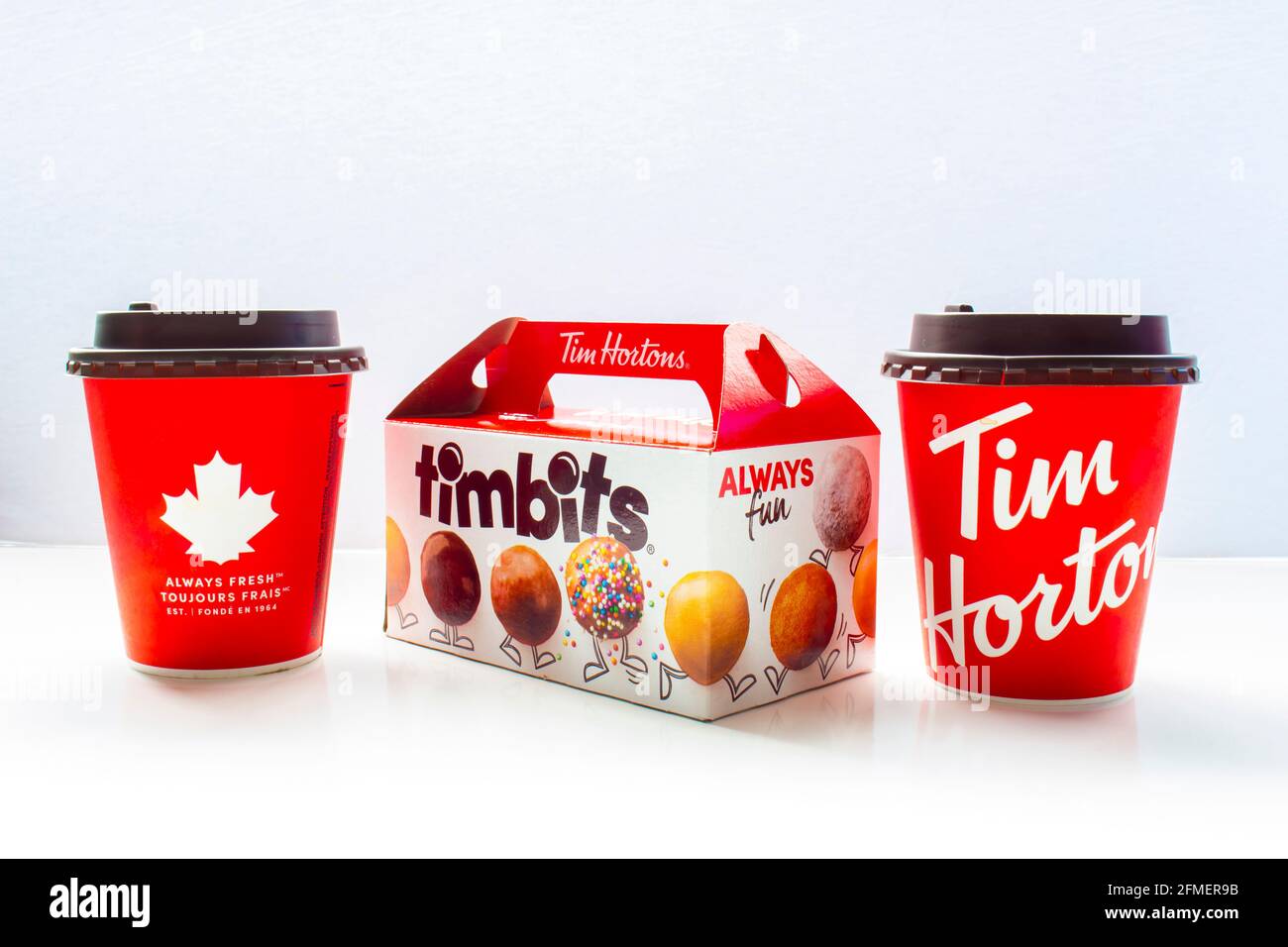 Calgary, Alberta Canada. 7 maggio 2021. Un paio di tazze da caffè Tim Hortons con una scatola di timbits. Foto Stock