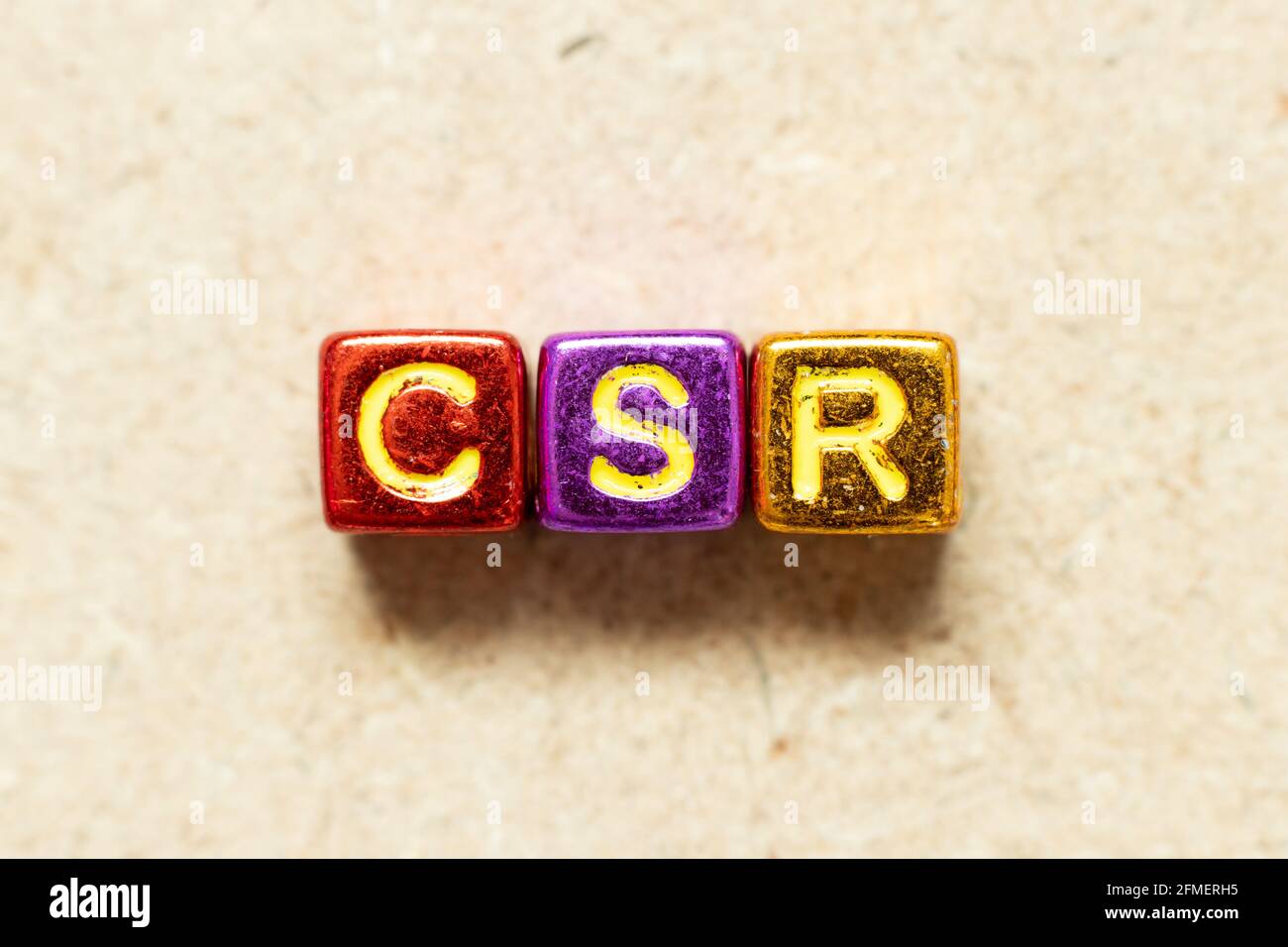 Blocco di caratteri alfabetici a colori in formato CSR (Abbreviazione di responsabilità sociale d'impresa) su sfondo di legno Foto Stock