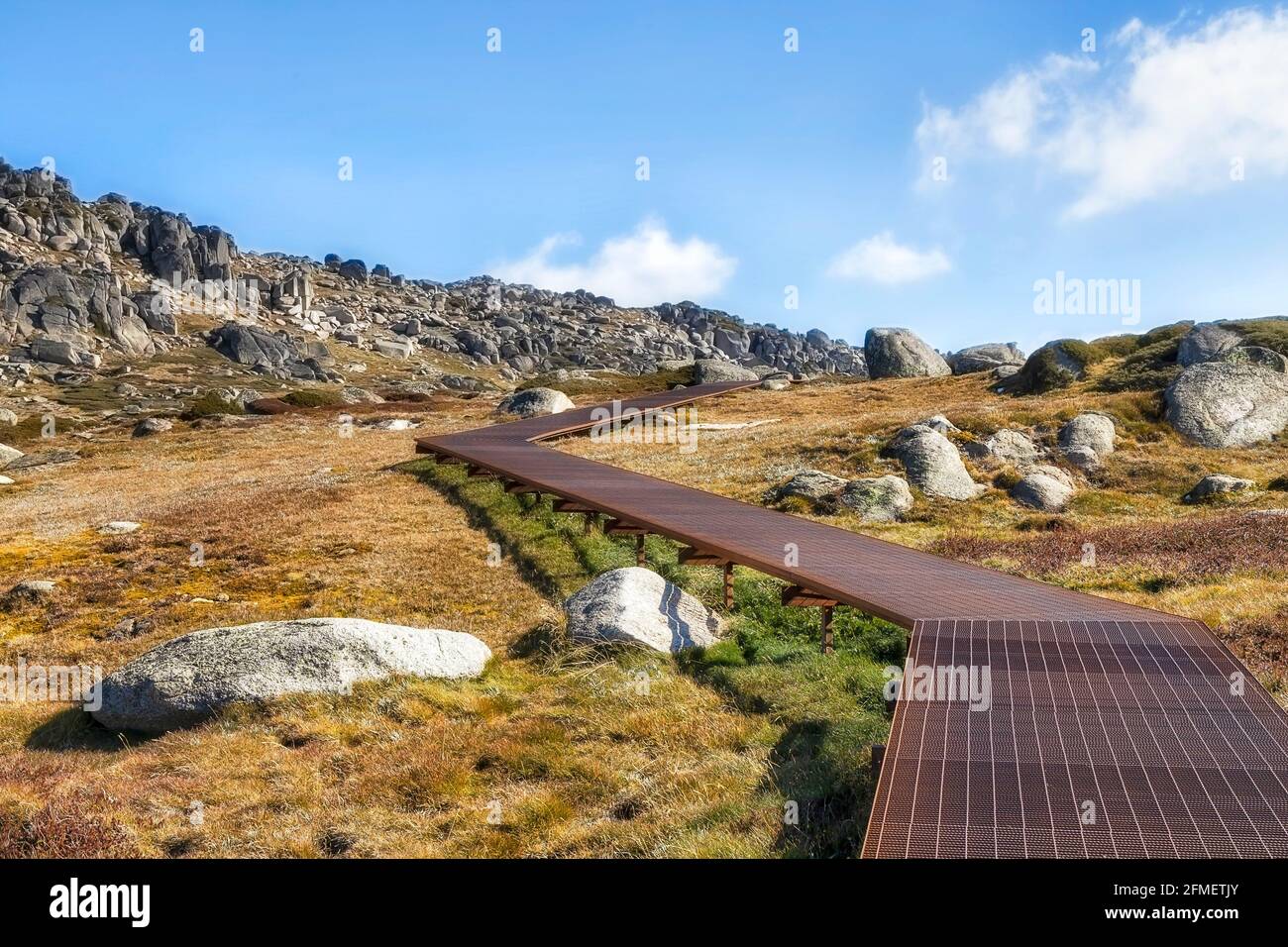 Passeggiata in boarwalk fino alla cima del monte Kosciuszko nel parco nazionale delle Snowy Mountains dell'Australia - soleggiata giornata autunnale. Foto Stock