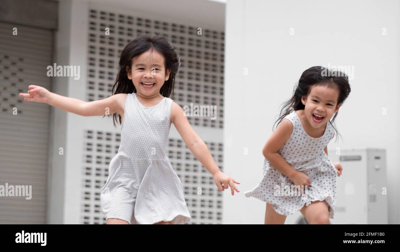 Felici due ragazze del fratello che giocano sul cortile domestico. Rimani a casa per la quarantena da pandemia di coronavirus. Foto Stock