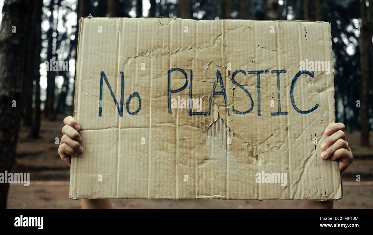 Striscioni con le mani che protestano per l'inquinamento e il riscaldamento globale nella foresta per salvare la terra del pianeta. Il concetto di Giornata Mondiale dell'ambiente. Foto Stock