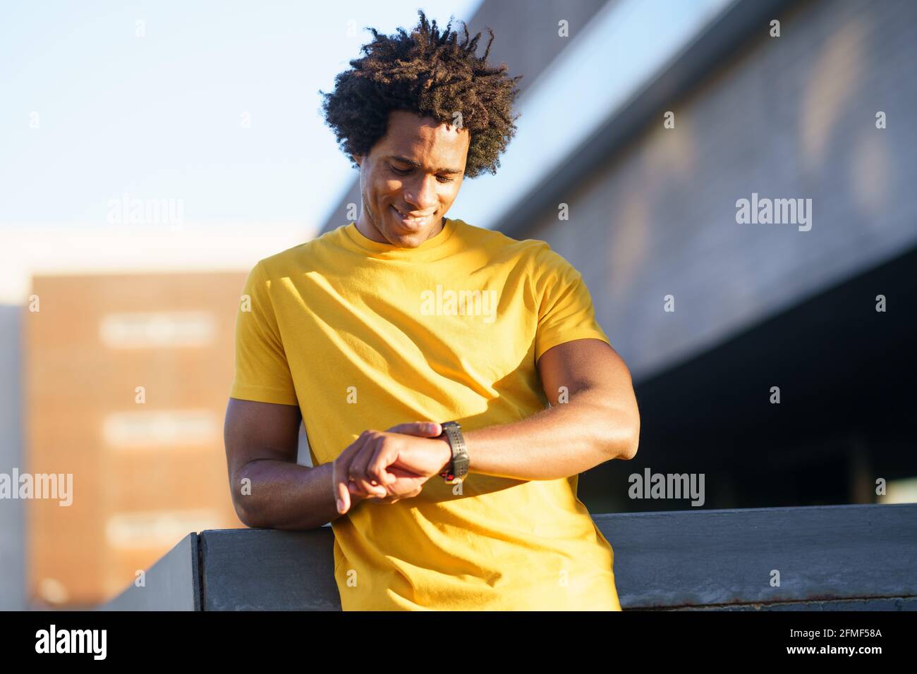 Black man ha consultato il suo smartwatch per visualizzare i suoi dati di allenamento. Foto Stock