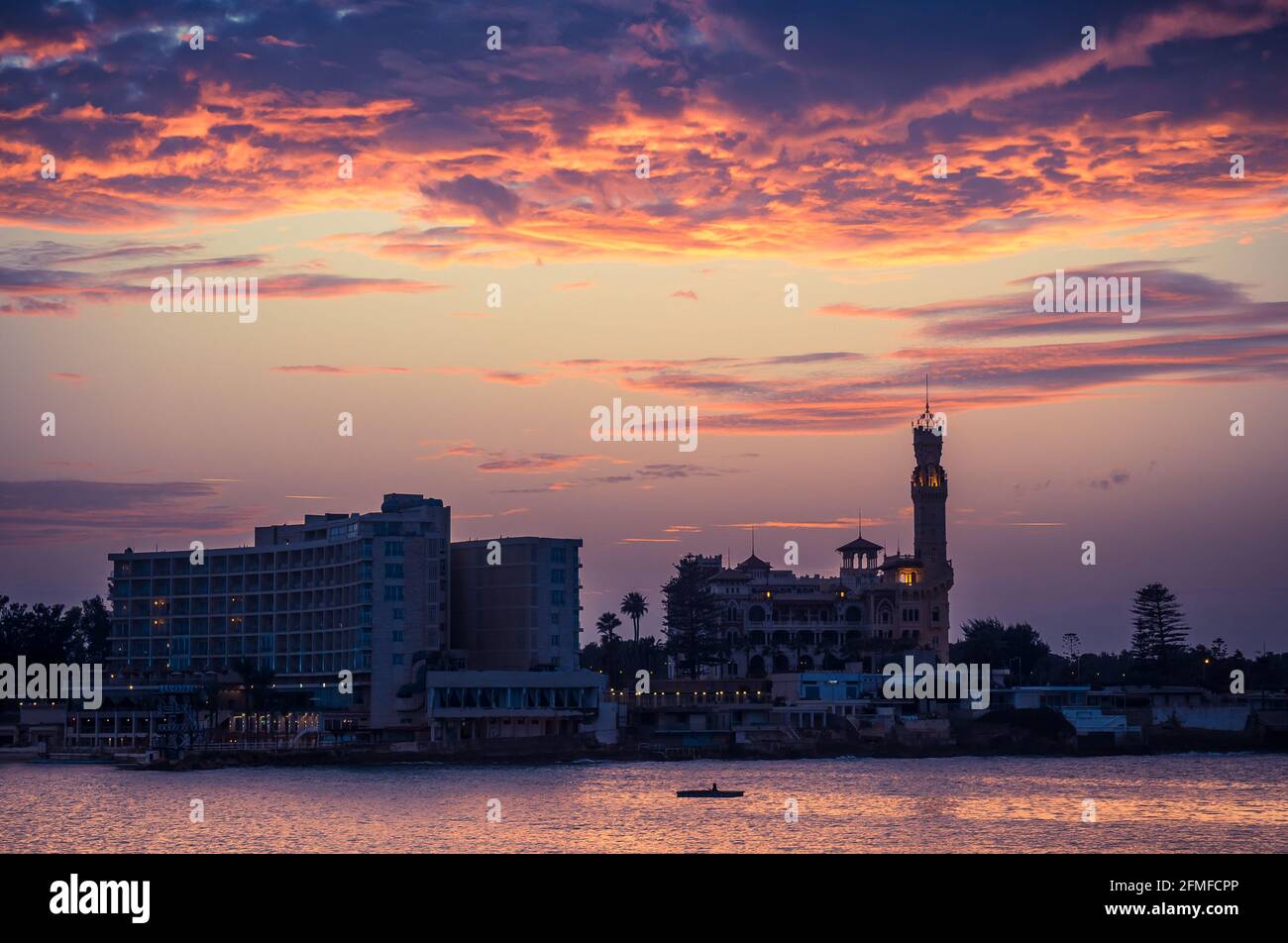 Tramonto sulla città di Alessandria con le sagome del Palazzo reale e del Parco di Montazah sul Mar Mediterraneo, Egitto. Foto Stock