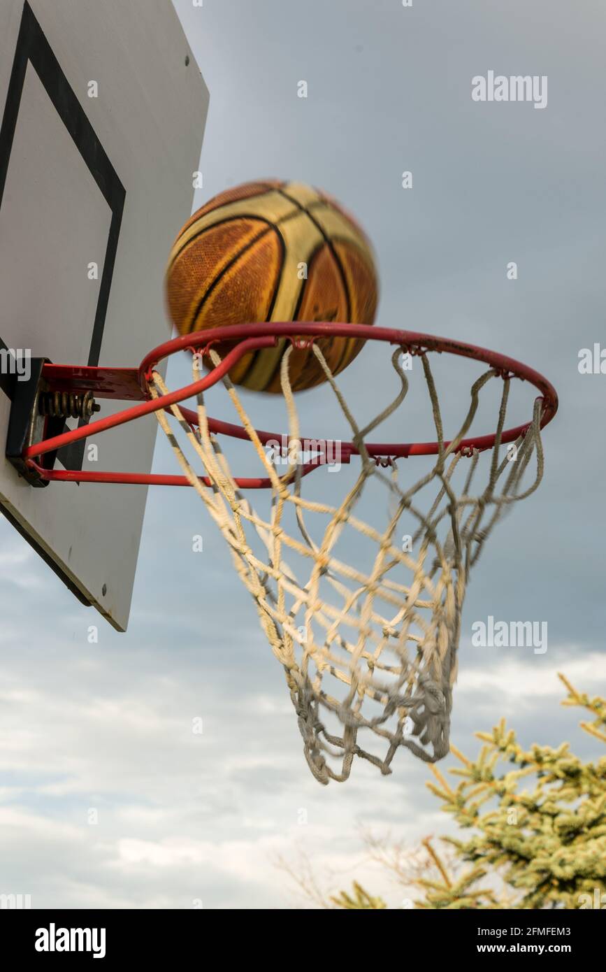 La pallacanestro attraversando hoop Foto Stock