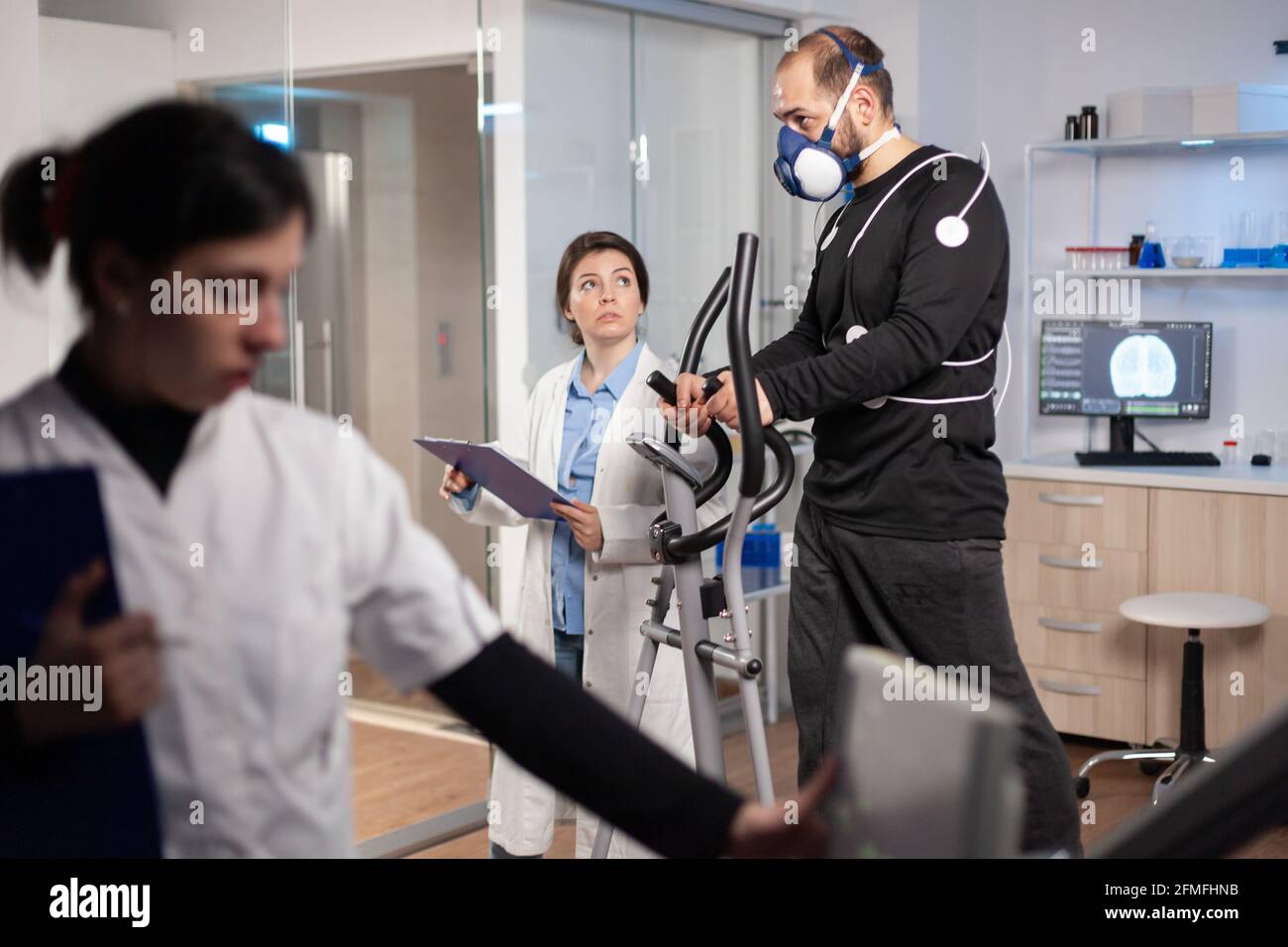 Prestazioni atleta test endurace in laboratorio sportivo, correndo con elettrodi sul corpo per il monitoraggio. Misurazione della frequenza cardiaca dell'esame cardiaco incrociato. Foto Stock