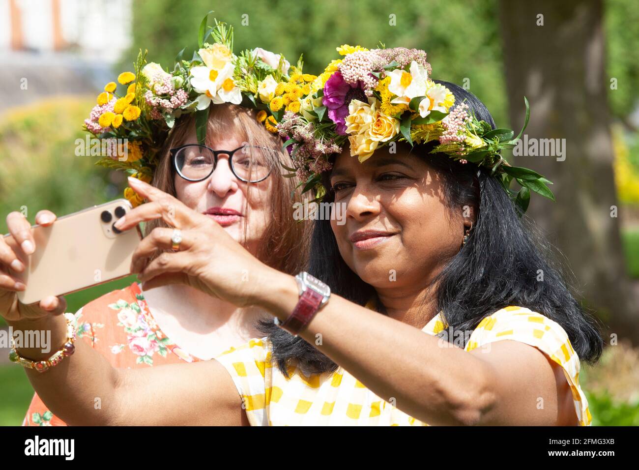 Londra, Regno Unito, 9 maggio 2021: Melanie, uno scienziato clinico (a  sinistra) e il suo amico fin dai giorni della scuola Bea, un ingegnere, (a  destra) posa con le corone di fiori