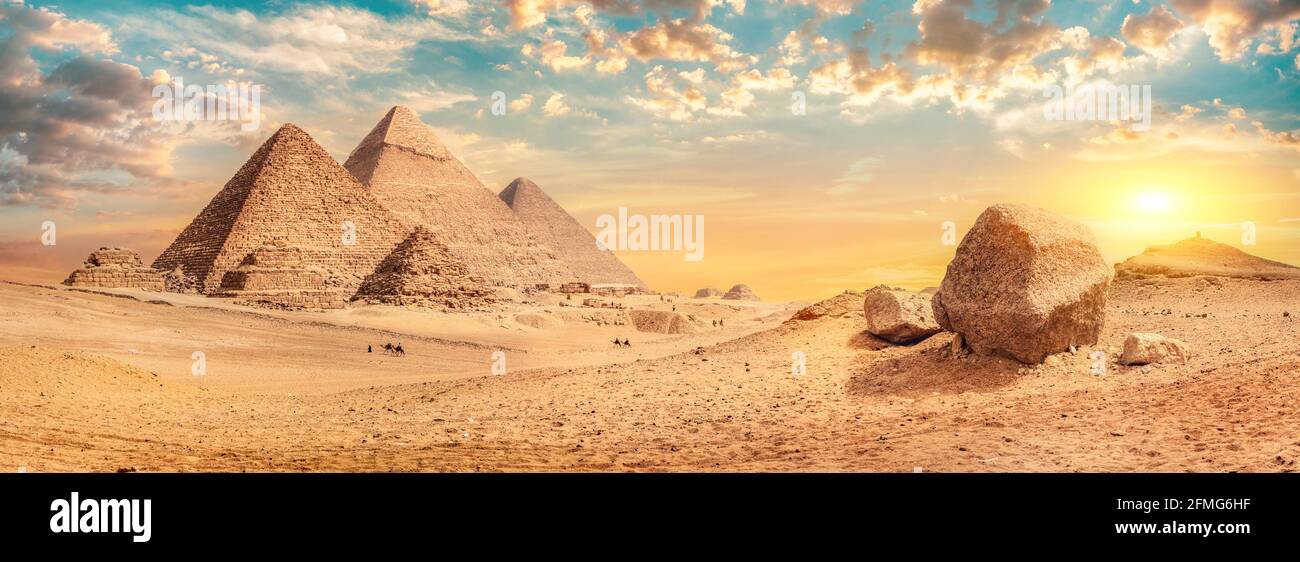 Fila di piramidi nel deserto di Giza al tramonto, Egitto Foto Stock