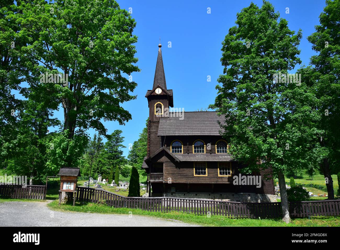 La chiesa in legno di Tatranska Javorina, un piccolo paese nel Tatry Belianske, con un cimitero e alberi. Slovacchia. Immagine presa da terra pubblica. Foto Stock