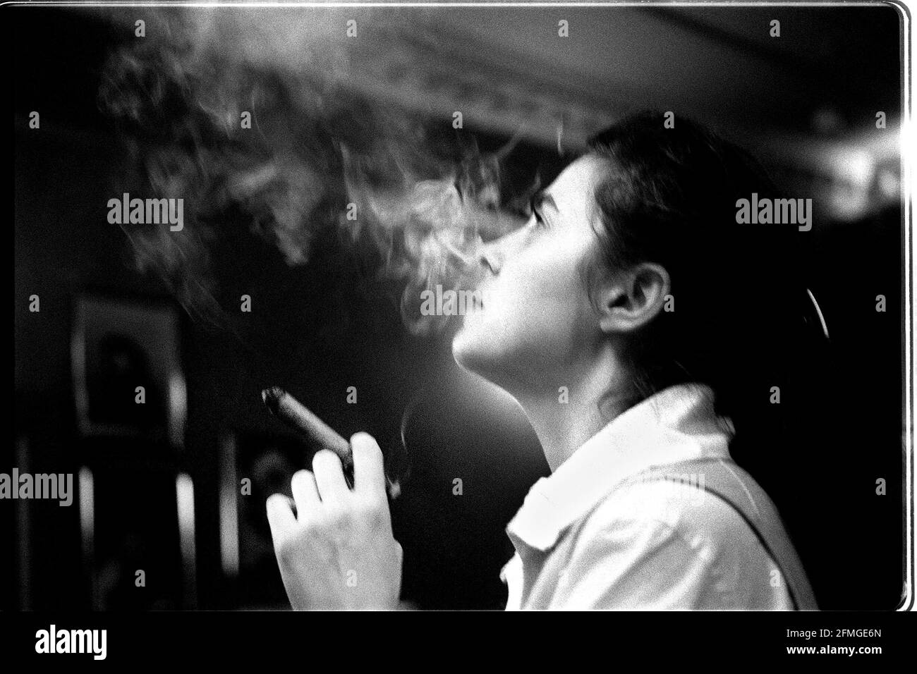 Donna che fuma sigaro 1997Christina Graham rilassato fumo nel numero Un Cigar Club su Percy Street a Londra Foto Stock