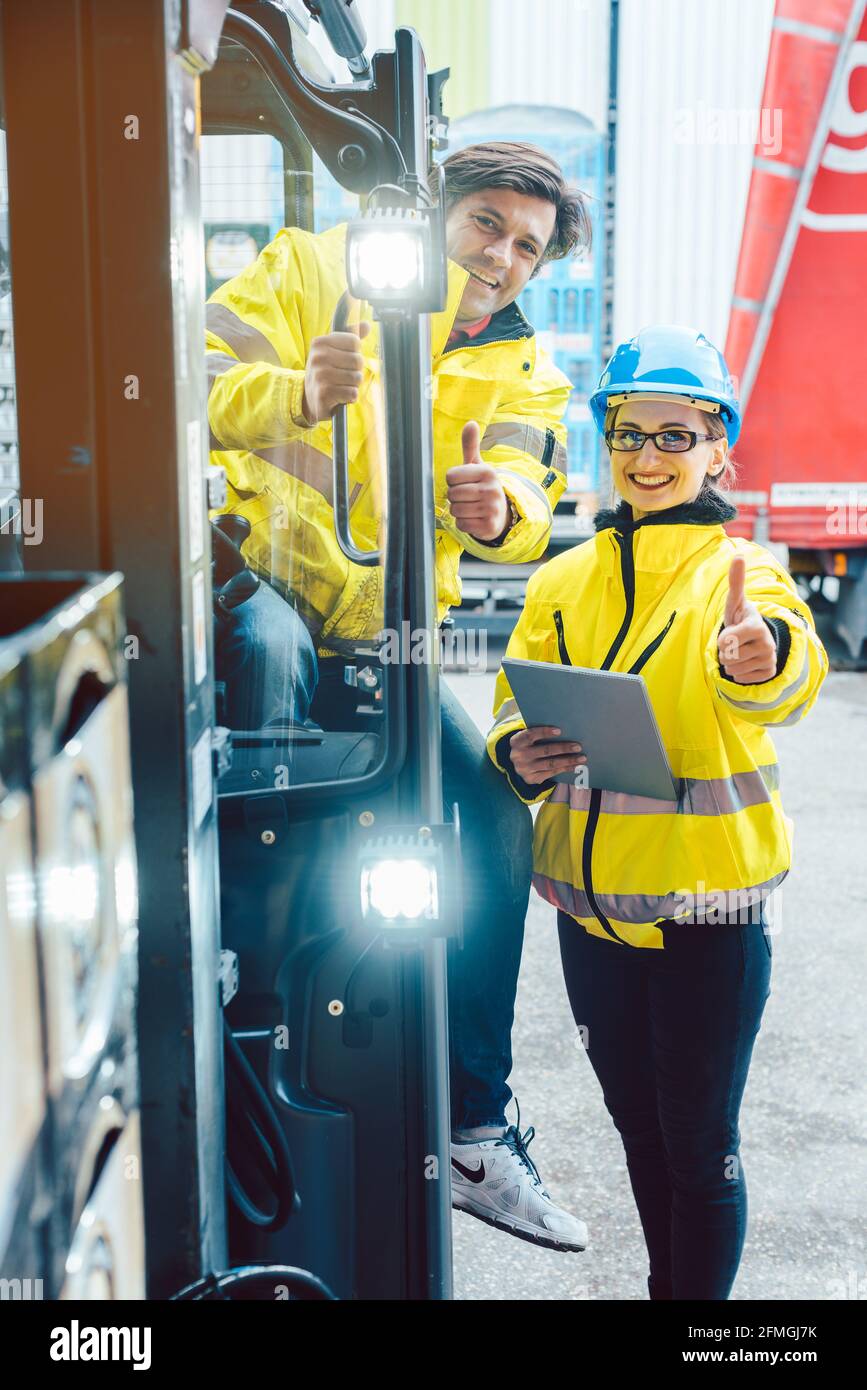 Il conducente del carrello elevatore a forche e forneoman discutere su dove conservare la consegna Foto Stock