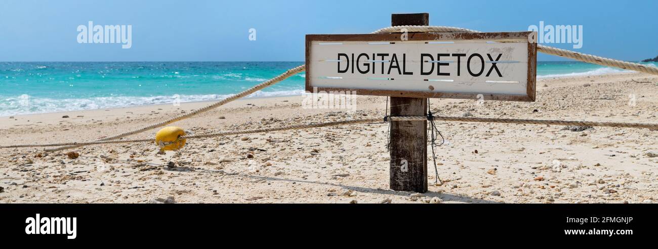 Vecchio segno di legno con testo detox digitale sulla spiaggia tropicale Foto Stock
